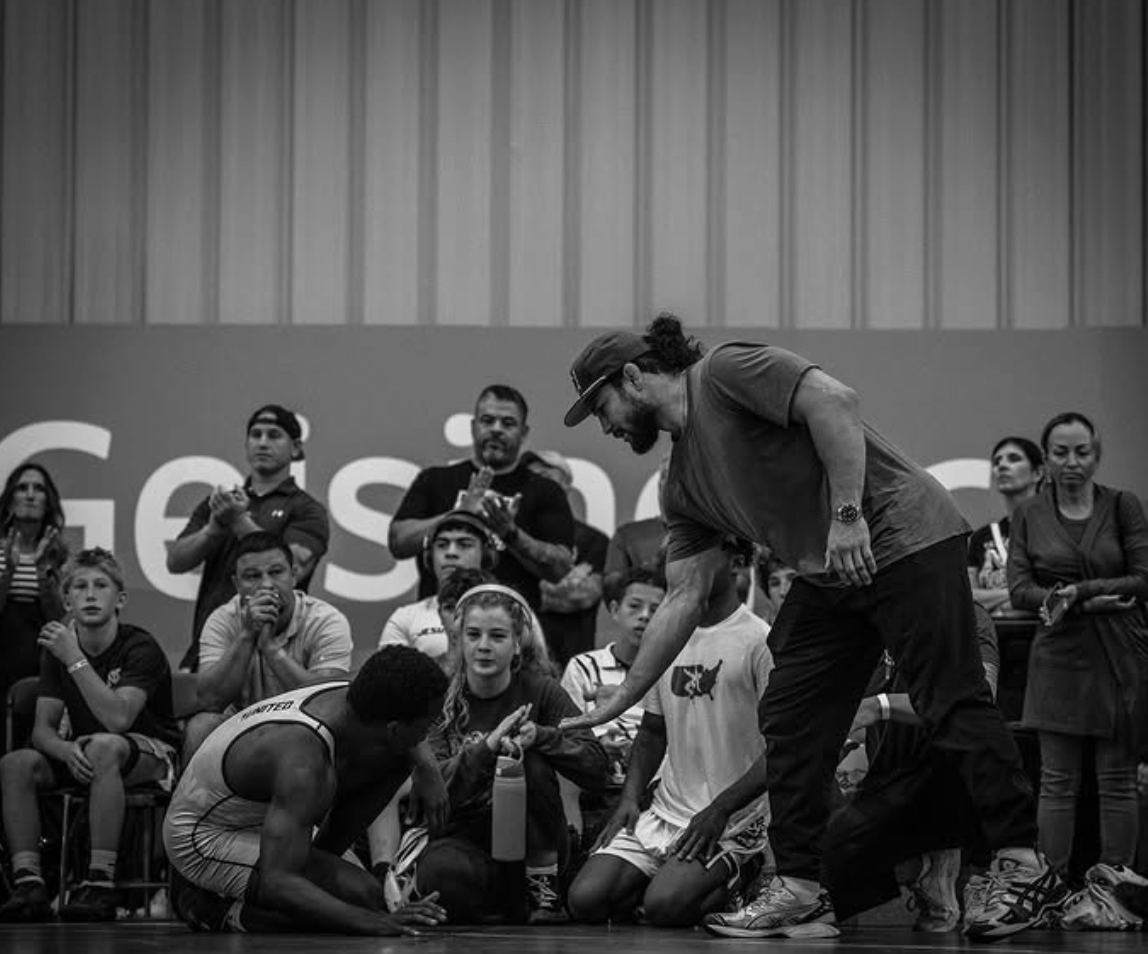 Coach giving instruction to wrestler - black and white
